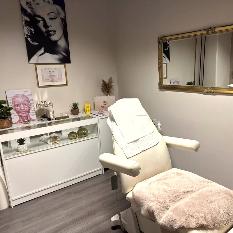 Behandlungszimmer mit weißem Stuhl und Gold-Spiegel
